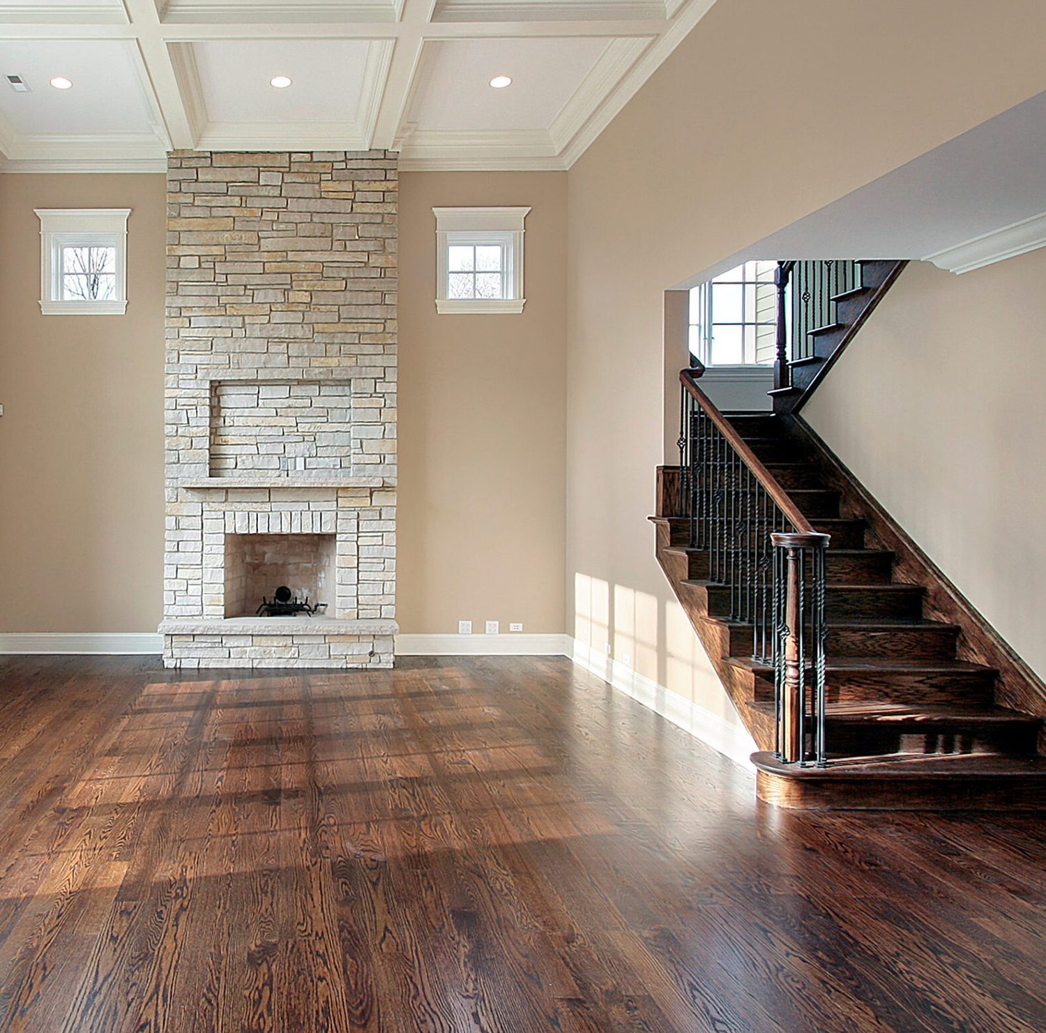 Red oak hardwood floor in a living room with a stone fireplace and coffered ceiling