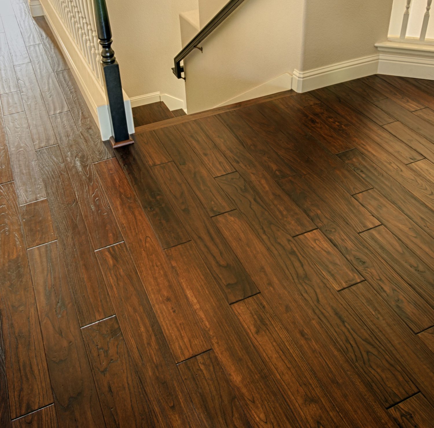 Dark engineered hardwood flooring running to a staircase